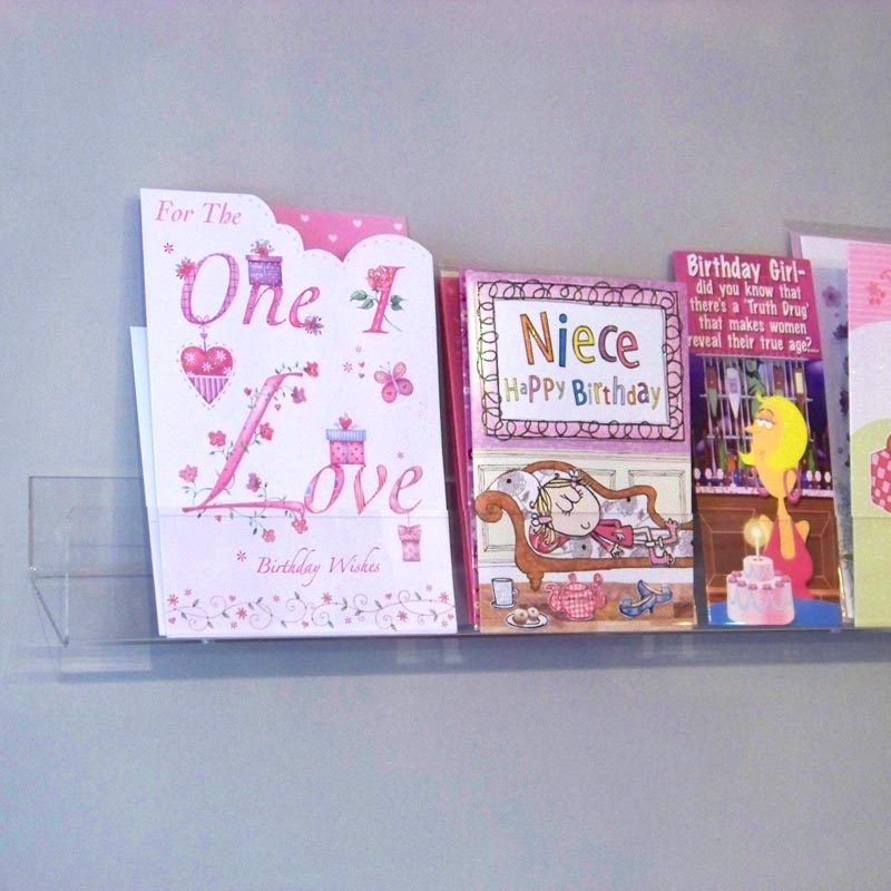 Side profile of standard greeting card rack installed on a wall.