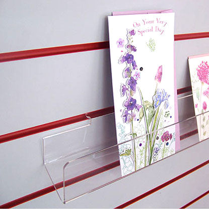 Side profile of standard greeting card rack installed on white slatwall.