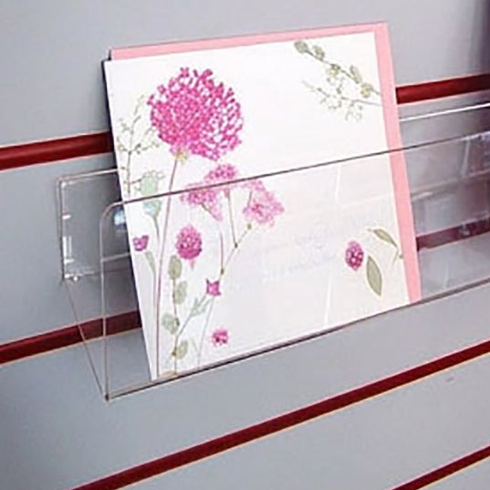 Side profile of deep greeting card rack installed on white slatwall.