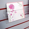Side profile of deep greeting card rack installed on white slatwall.
